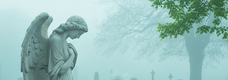 Eine Engelsstatue, im Hintergrund Bäume